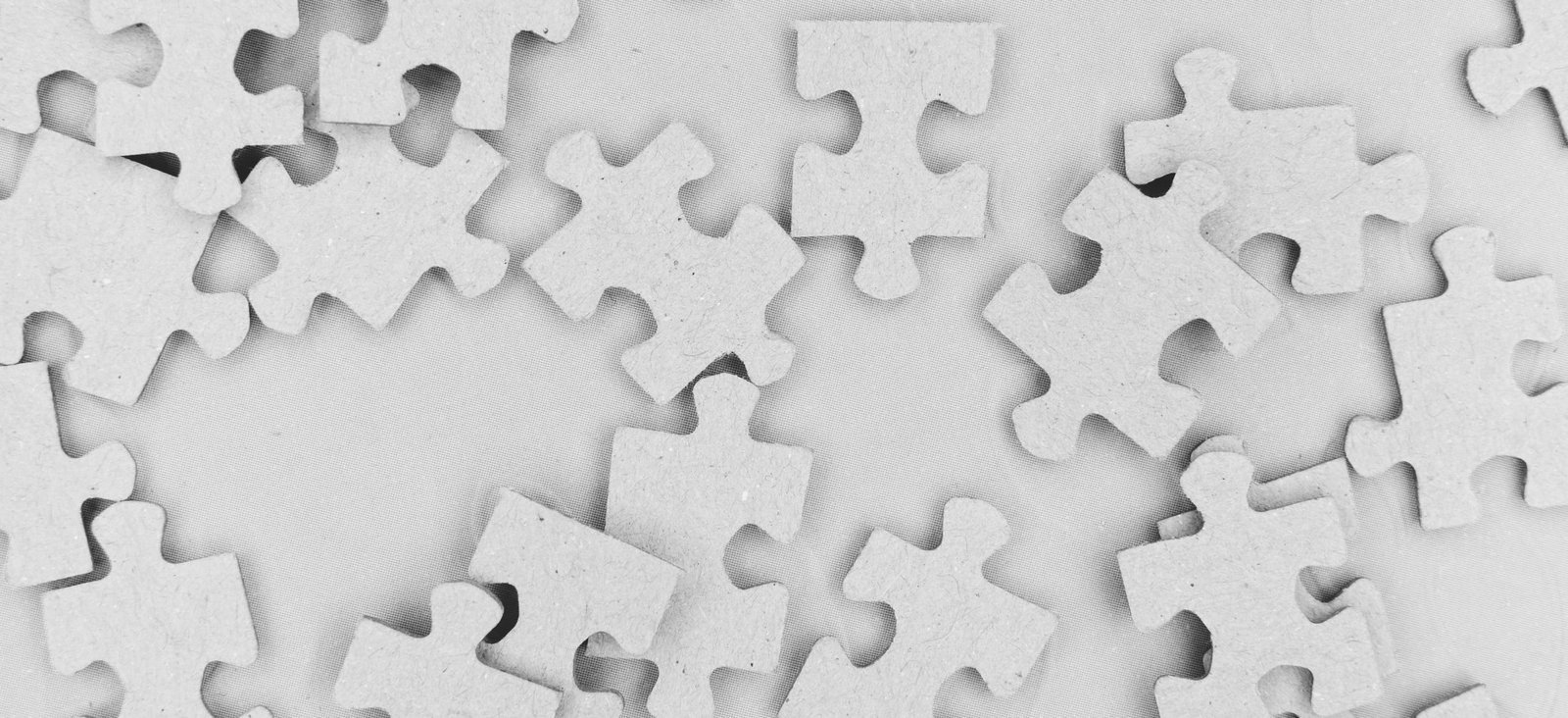 Gray generic puzzle pieces scattered against a gray background