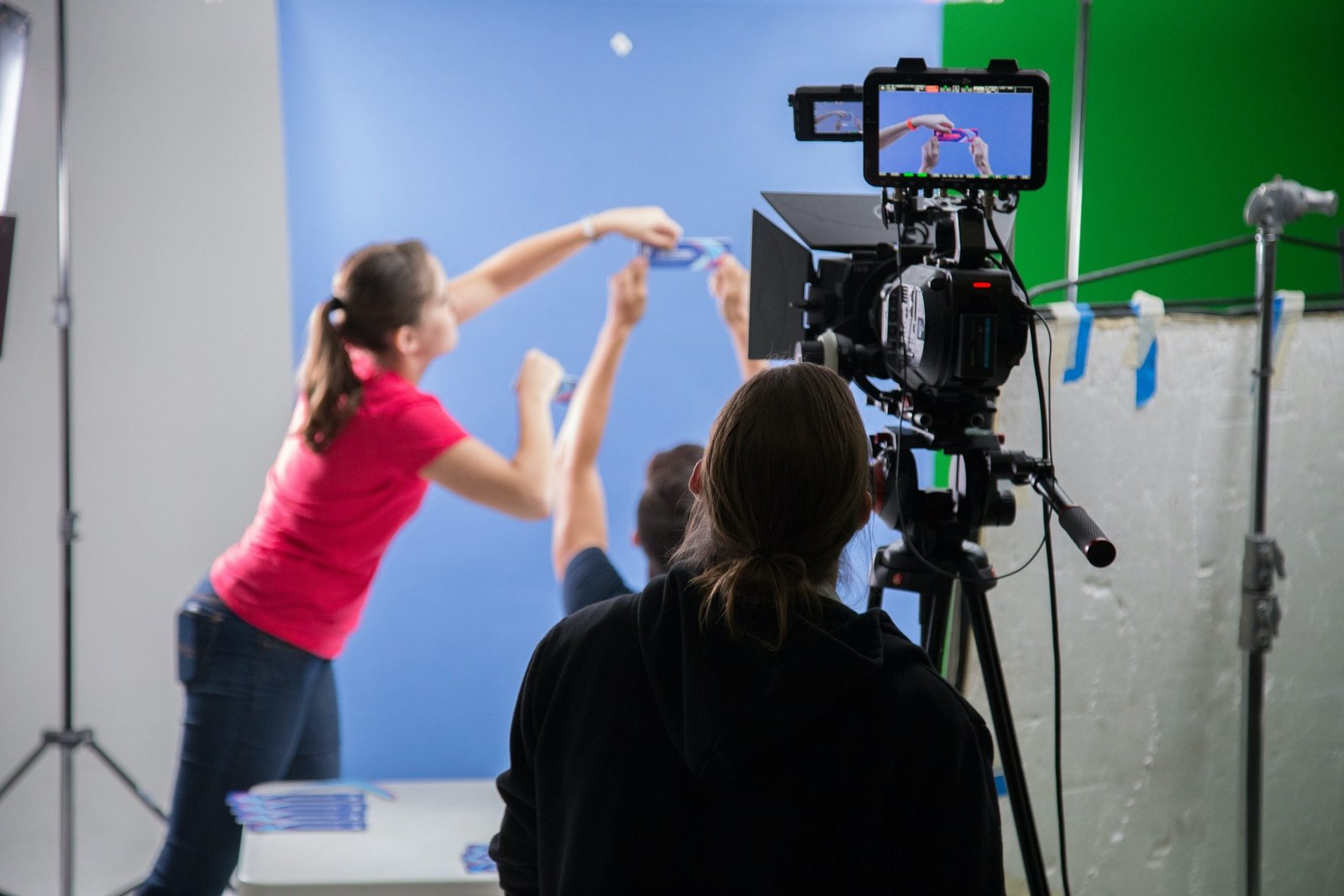 A woman placing a product in front of a camera for an advertisement in a studio