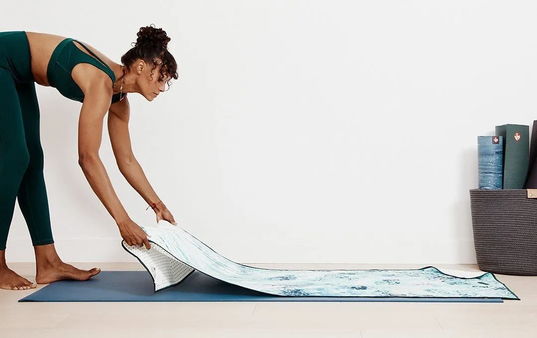 Woman laying out her Manduka yoga mat