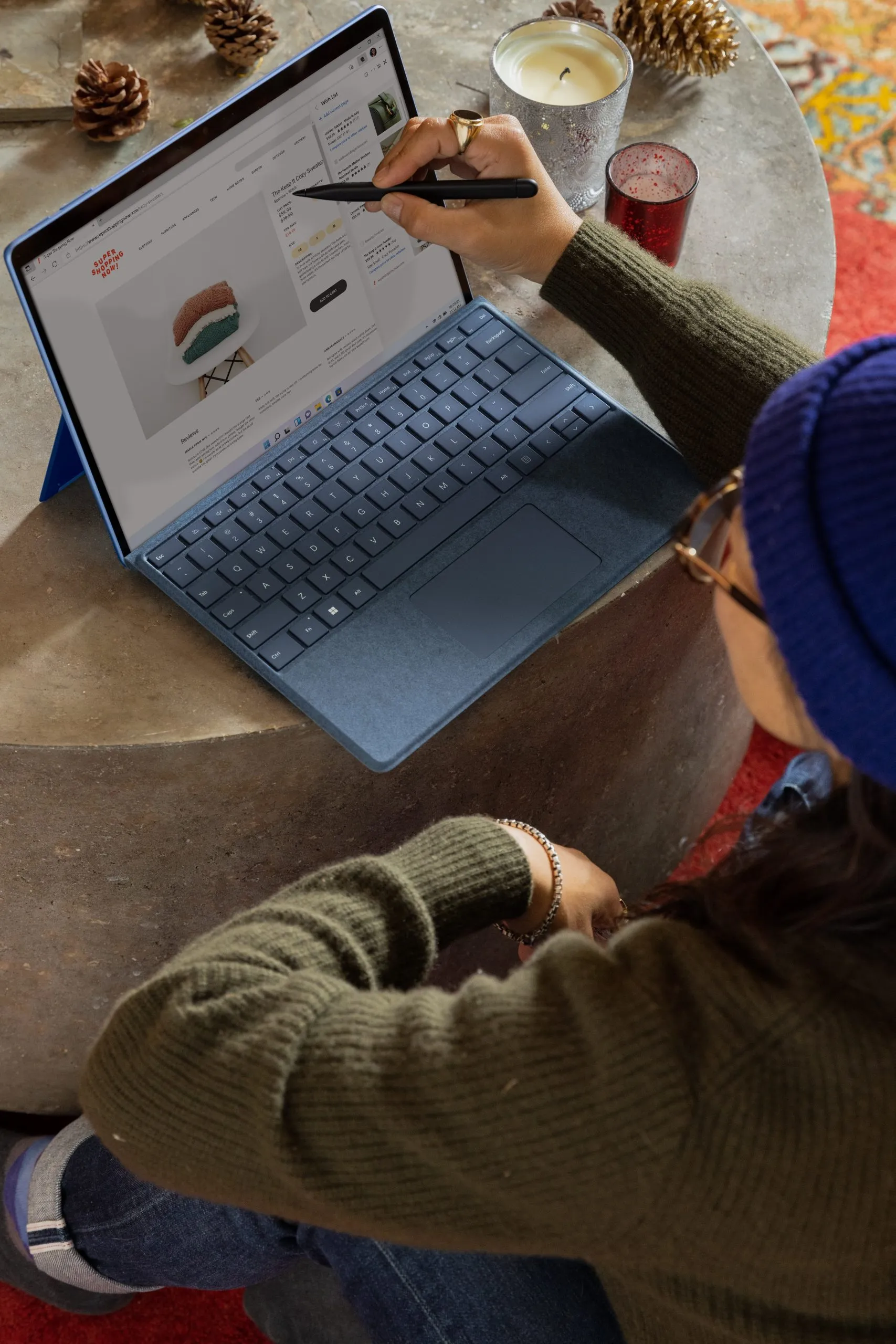 Someone using a pen to point at something on their laptop screen