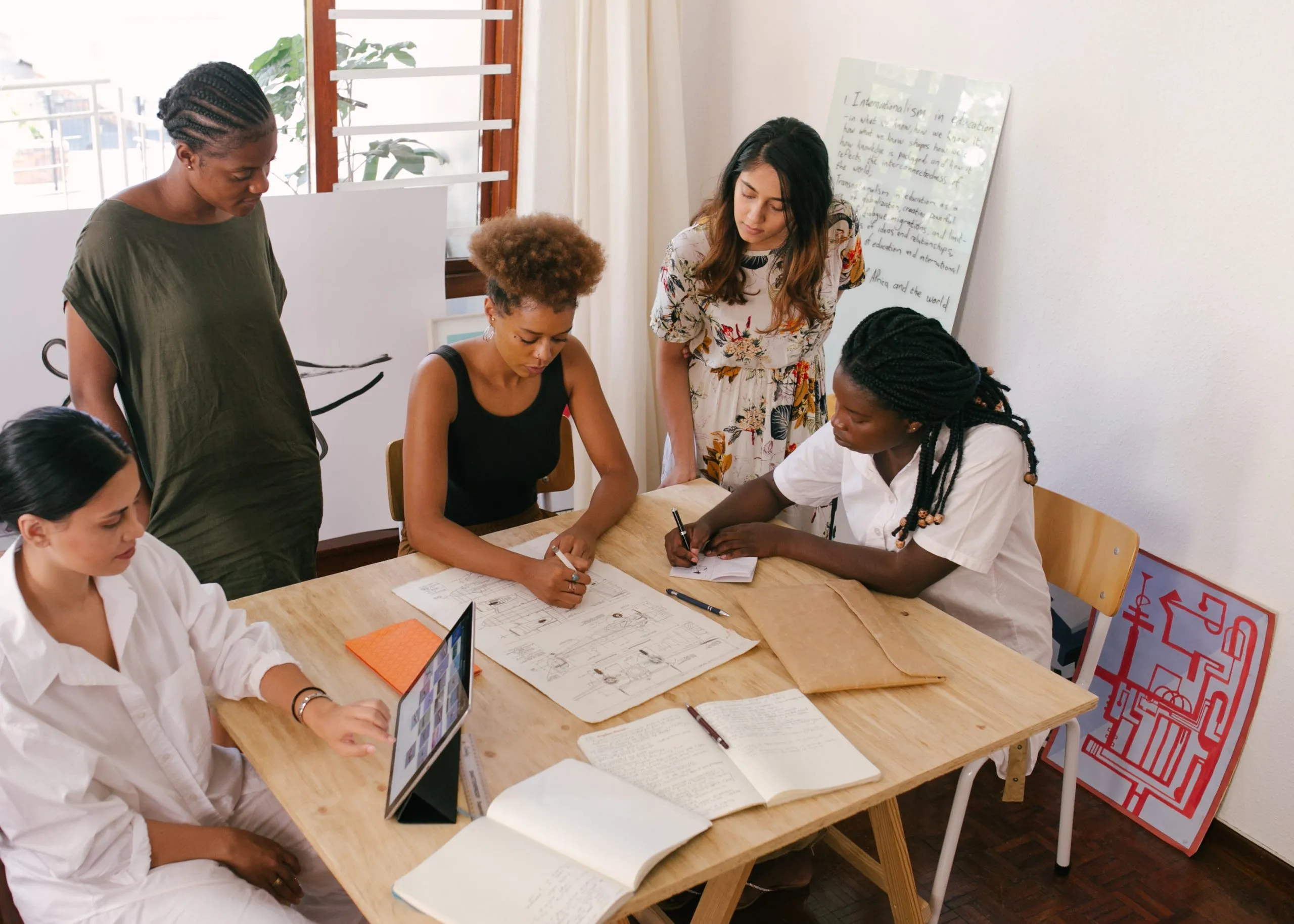 Team members gathered around a table working on a project
