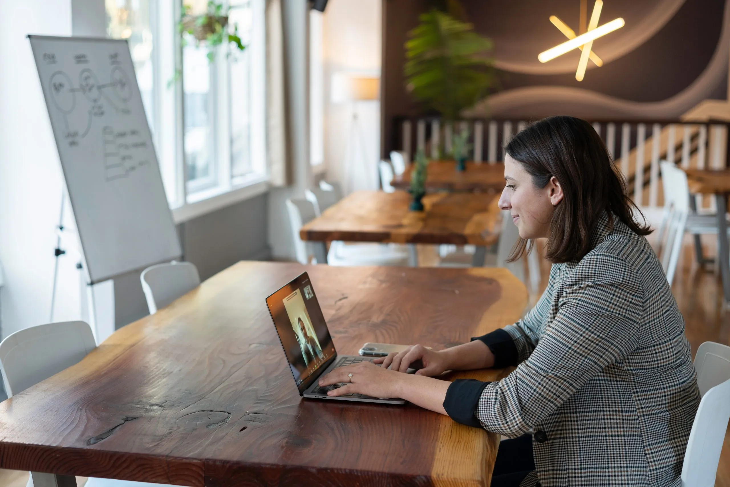 Woman smiling and sitting at a table on a video call