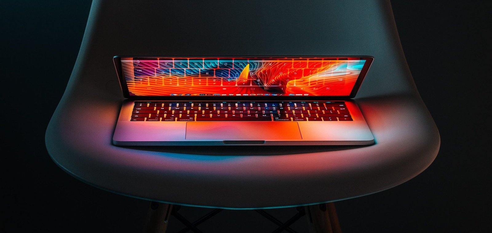 futuristic photo of a laptop halfway open lighting up the chair it's sitting on