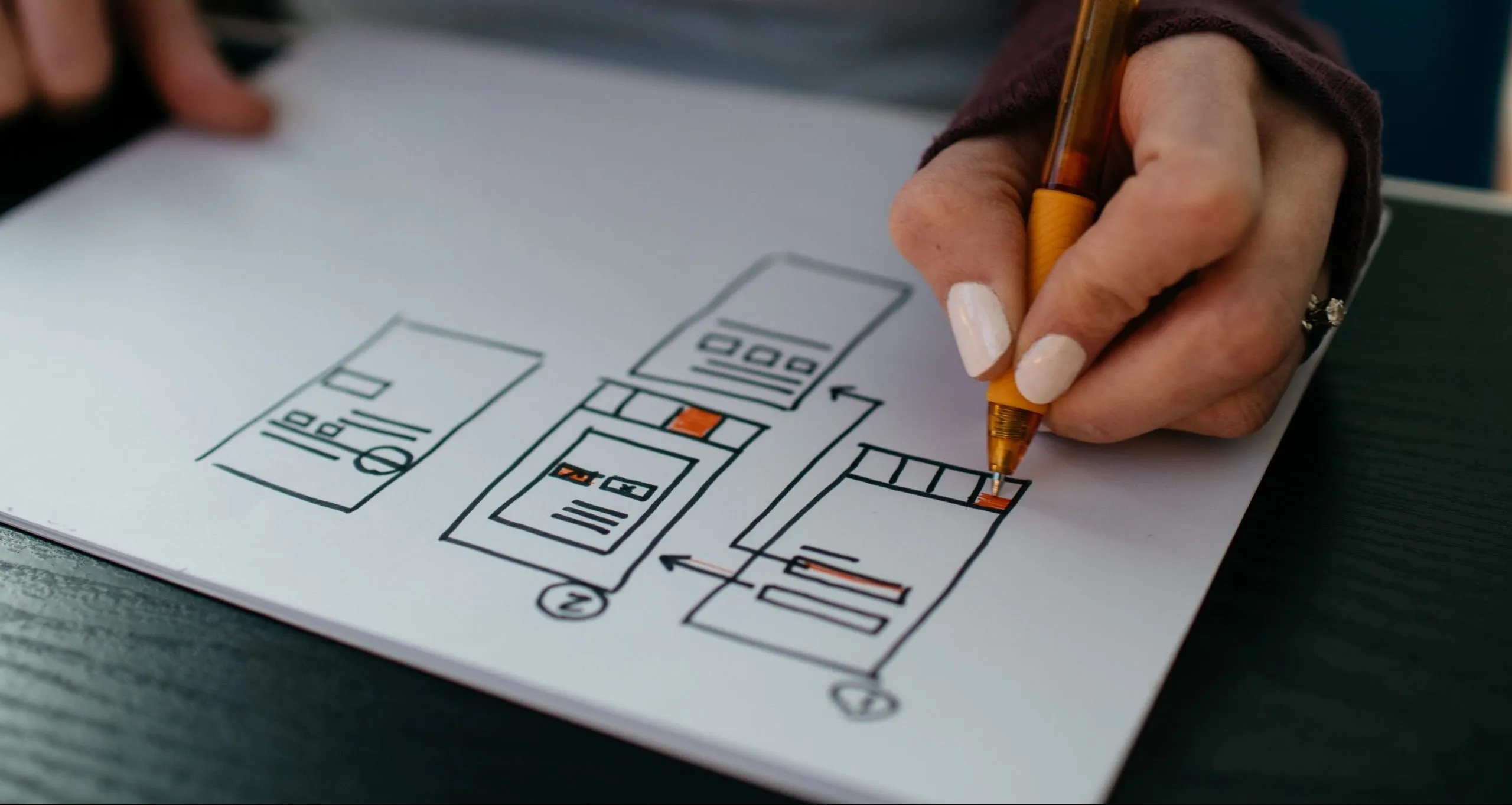 Someone drawing mockups of menu/page layouts for a smartphone