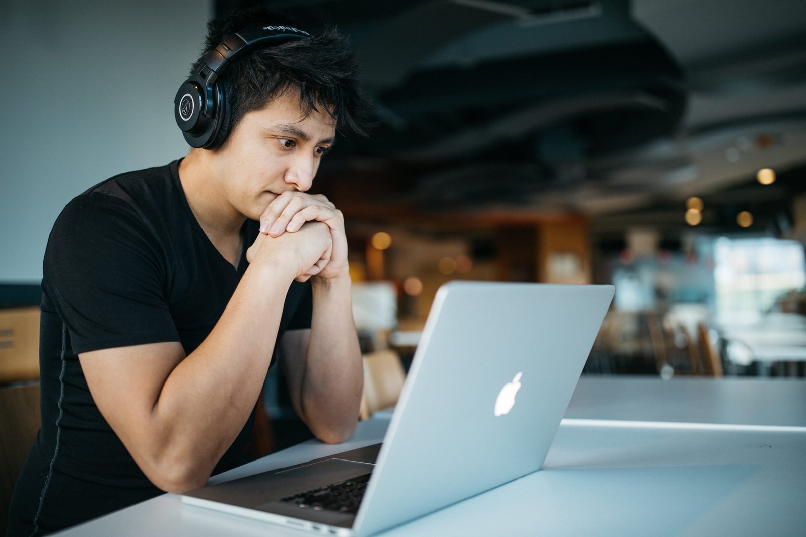 Man wearing headphones focused on a laptop