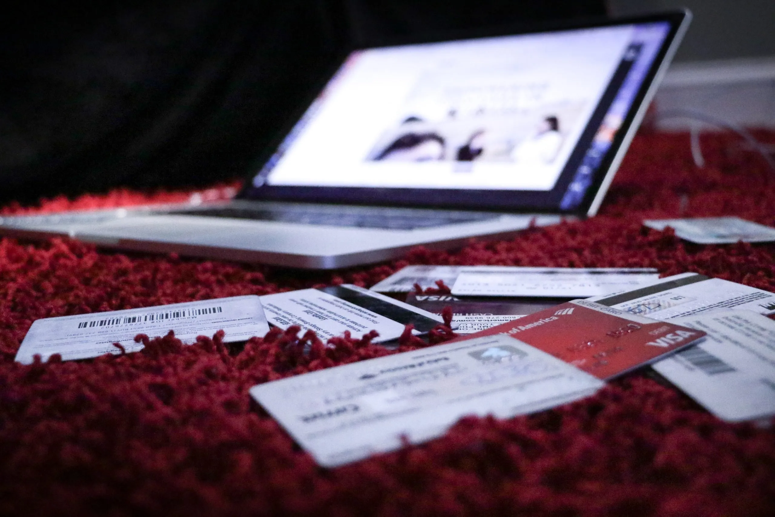 credit cards scattered on a rug next to a laptop