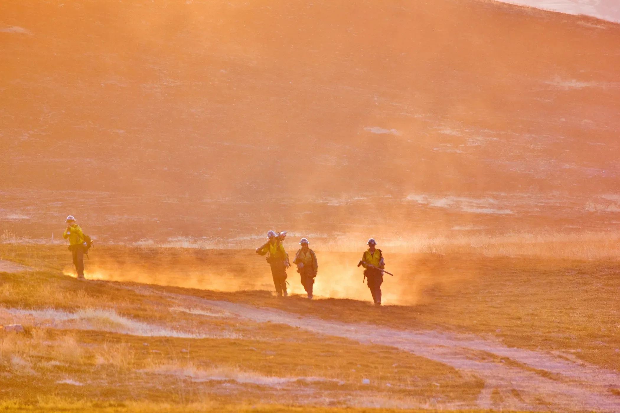 firefighters walking through a field