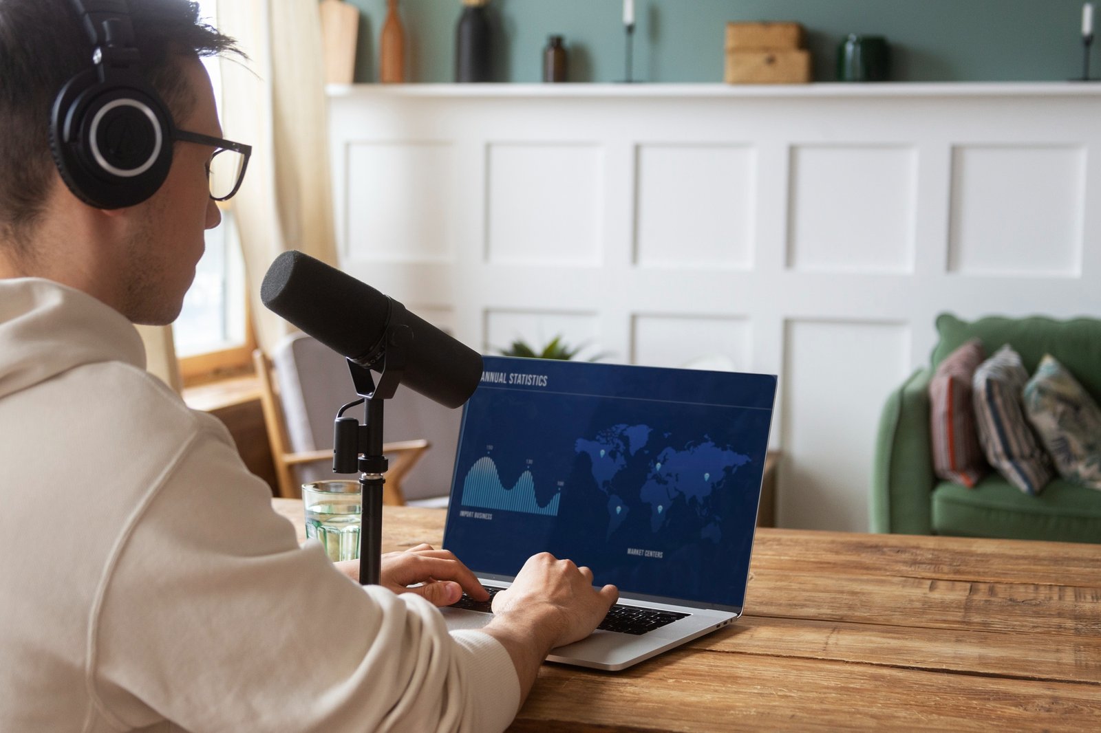 Man with Mic looking at stats on laptop