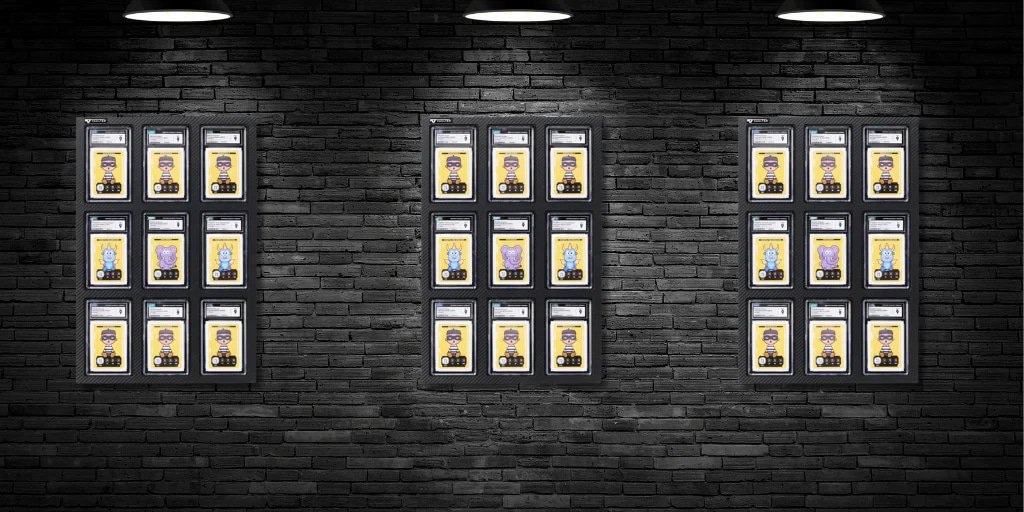 Three Vaulted display cases with graded trading cards mounted on a brick wall.
